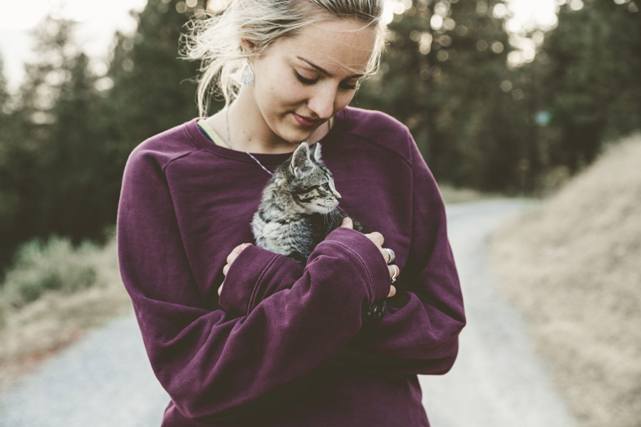 young woman holding cat outdoors