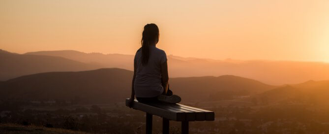 self care, woman sat on hill top