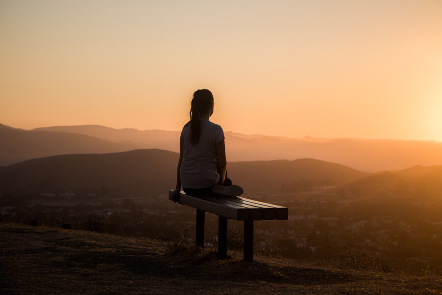 self care, woman sat on hill top