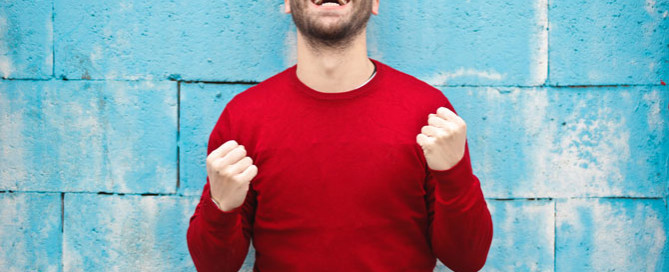 happy man wearing red jumper, managing difficult clients